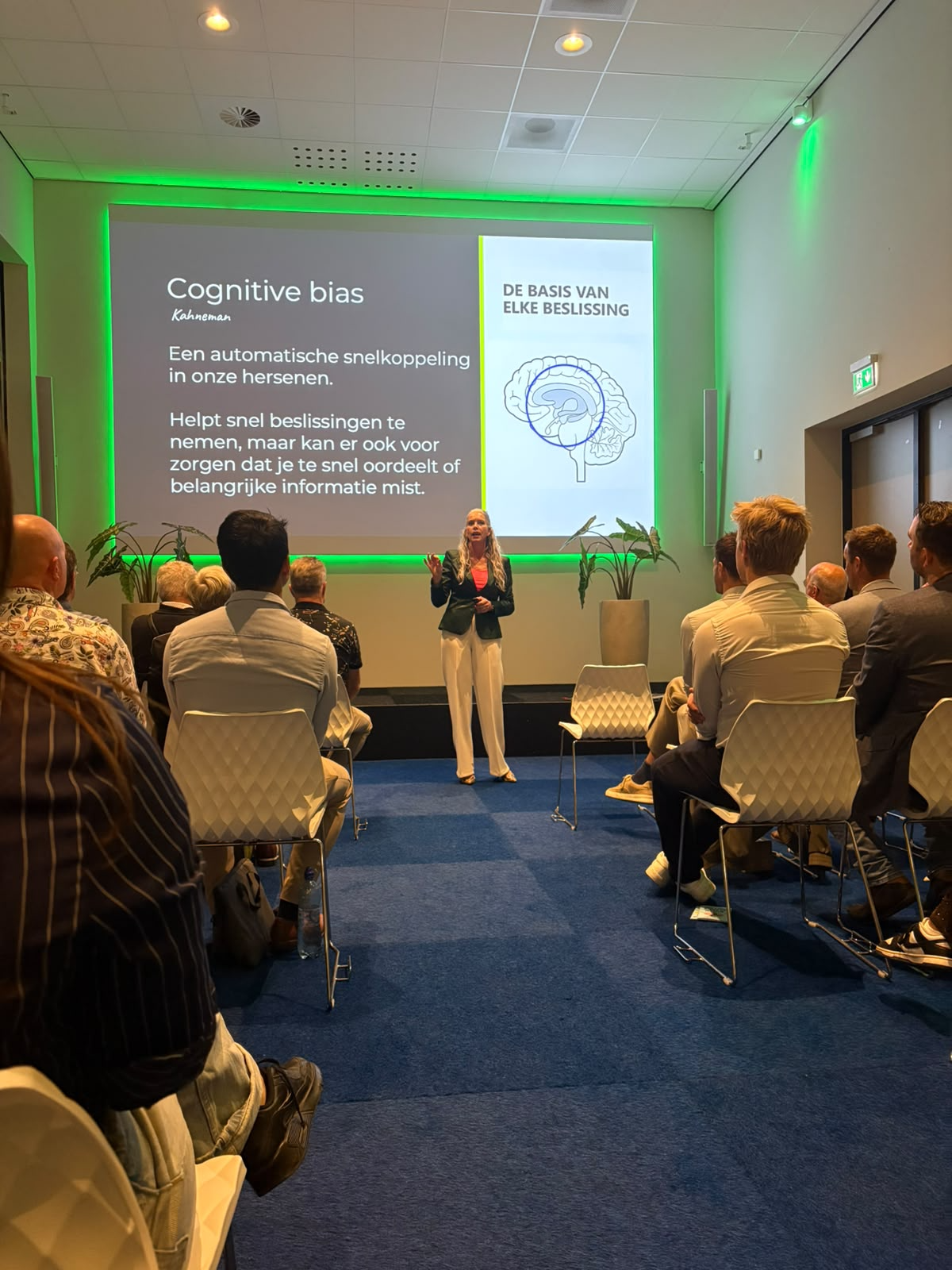 Chantal geeft een keynote over cognitive bias en de basis van elke beslissing voor een zaal vol publiek